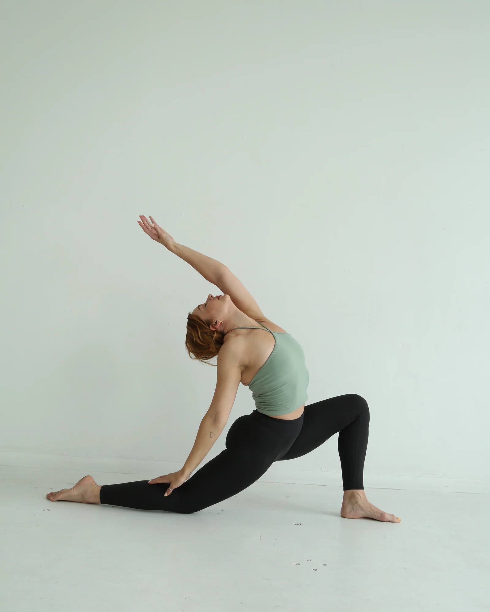Shannon reaching through a grounded studio movement practice
