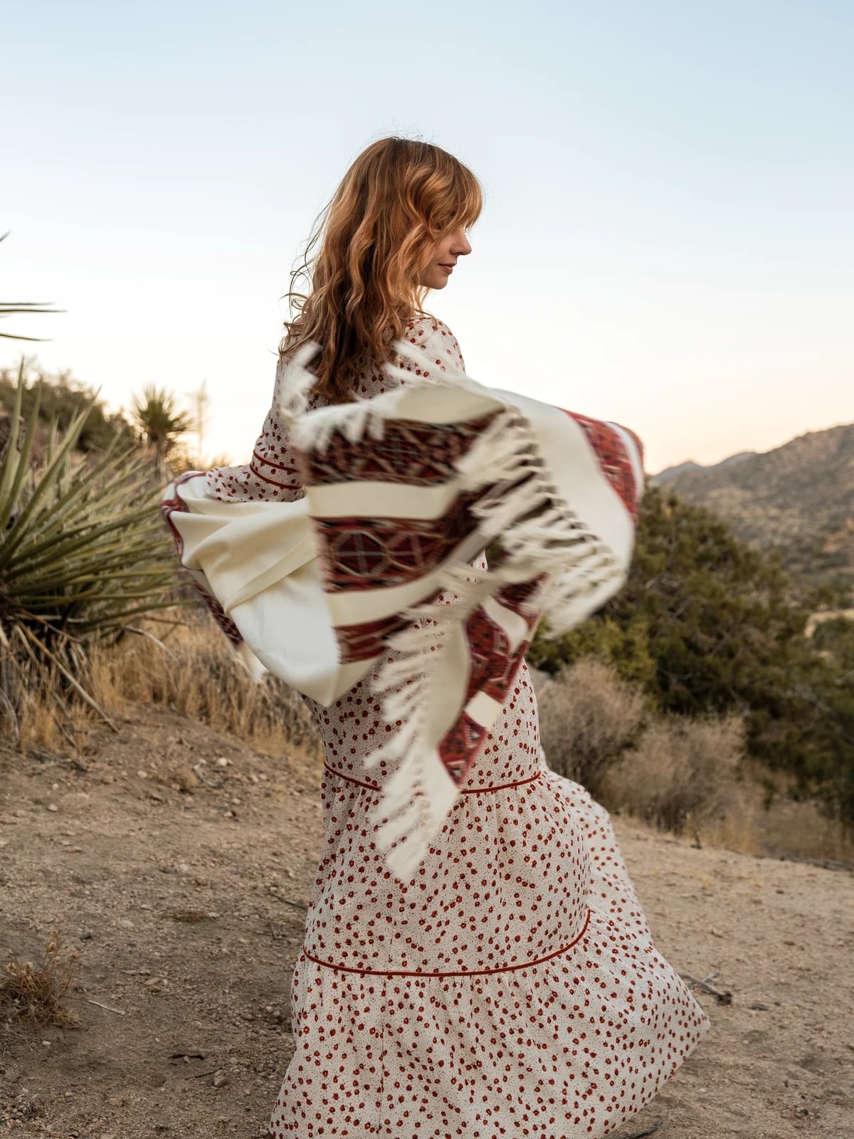 Shannon moving with a woven textile in the high desert