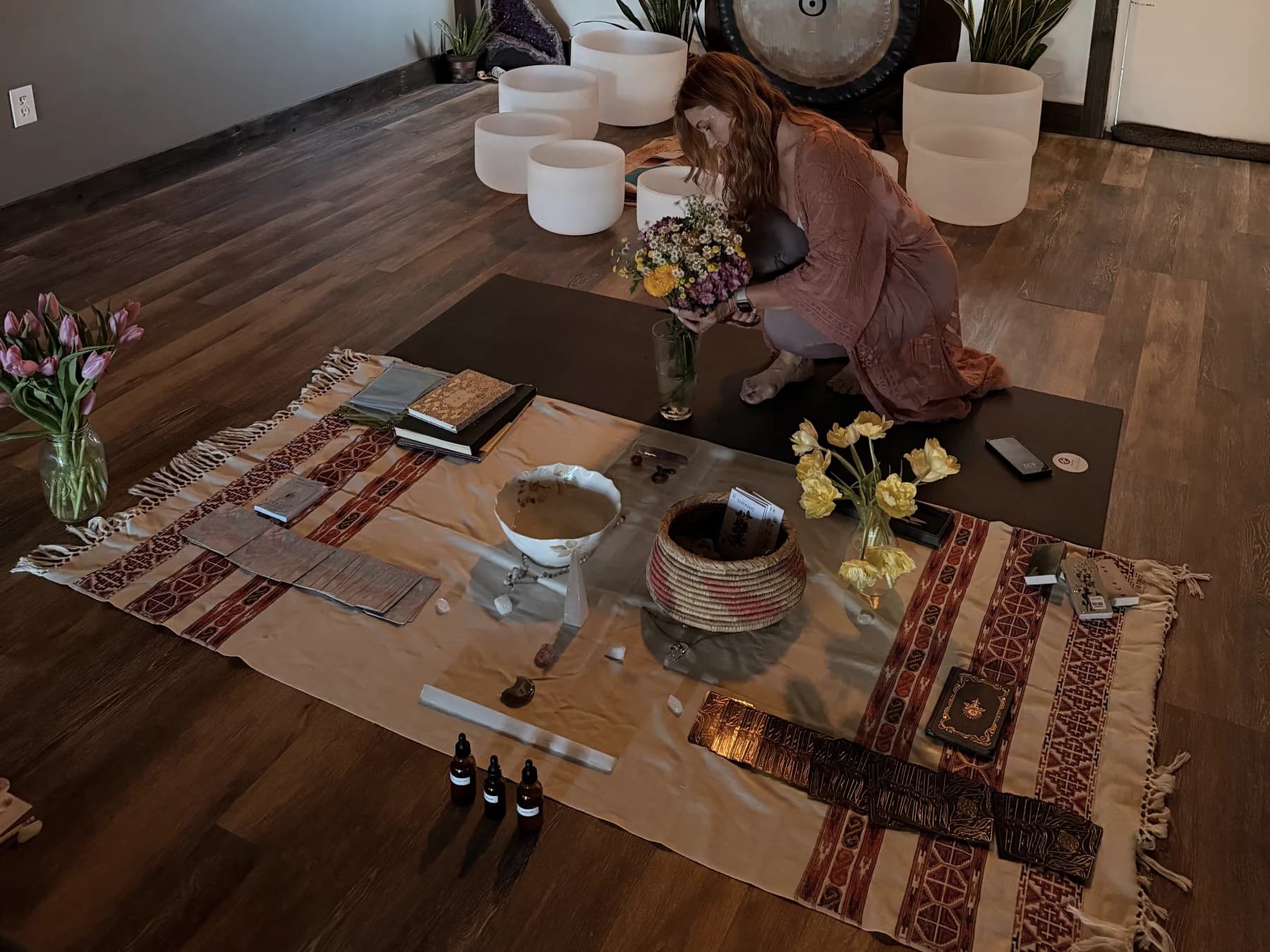 Shannon preparing flowers, sound bowls, and cards for a private ritual